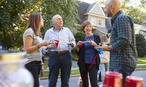 Middle aged and senior neighbours talking at a block party