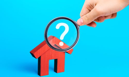 Realtor examines houses through a magnifying glass. Real estate market review. Quality of housing and availability of infrastructure. Verification of declared compliance. Price, location, legality